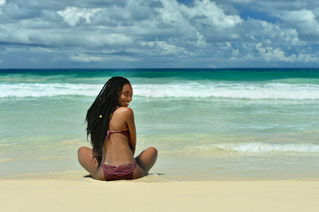beautiful young girl sitting on the beachの写真素材