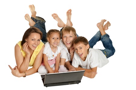 Cute family lying on a floor with laptop isolated on whiteの写真素材