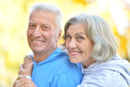 Happy senior couple in autumn park close-upの写真素材