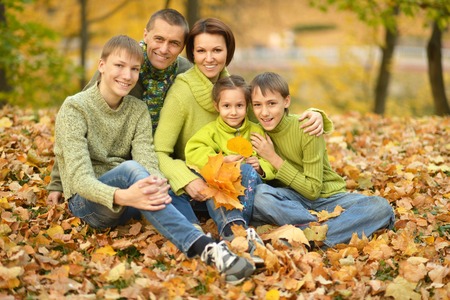 Happy smiling family relaxing in autumn parkの写真素材