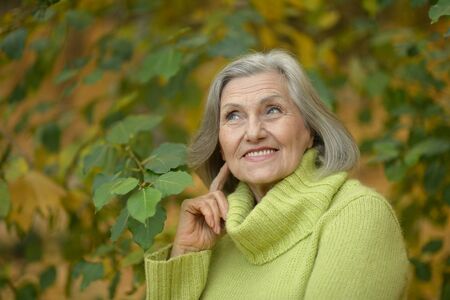 Autumn portrait of a beautiful middle-aged woman on the nature