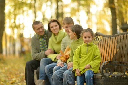 Happy smiling family relaxing in autumn parkの写真素材