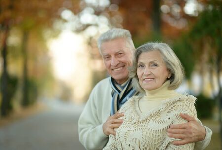 Happy senior couple relaxing in autumn park