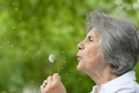 Portrait of an elderly woman on a walk in the park in late springの写真素材