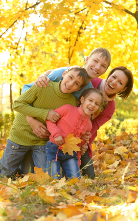 Happy smiling family relaxing in autumn parkの写真素材