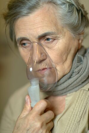 Sick Senior woman with inhaler close upの写真素材