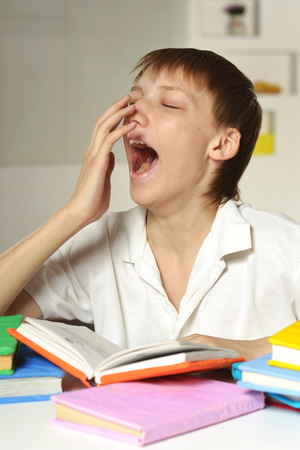 Schoolboy doing homework on the floor at homeの写真素材