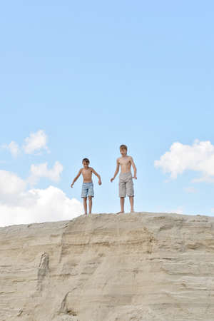 Two cute boys on a sandy hillの写真素材