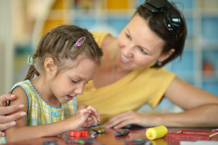 Little girl playing with her mother at homeの写真素材
