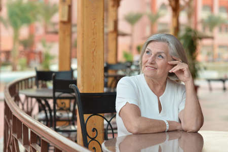 Nice elderly woman sitting at cafe tableの写真素材