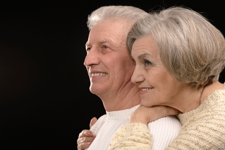 ortrait of older couple embracing on a black backgroundの写真素材