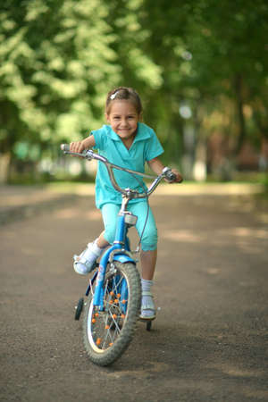 Little girl with bicycle outdoors in summerの写真素材