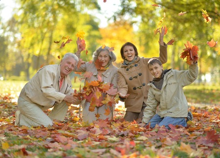 Happy smiling family relaxing in autumn parkの写真素材