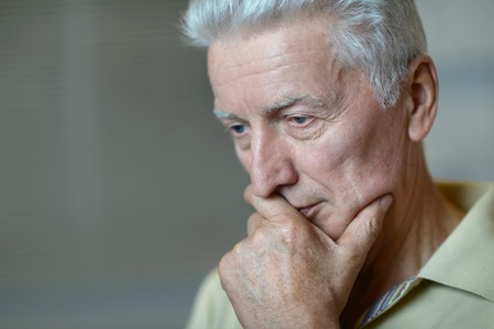 close-up portrait of a senior man thinking about somethingの写真素材