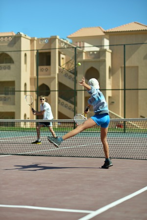 Two cute brothers playing at tennis courtの写真素材