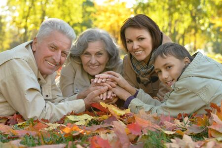 Happy grandmother with boy resting in the autumn parkの写真素材
