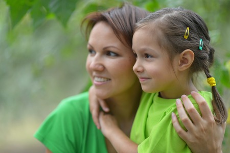 Little cute girl with her mother in summer parkの写真素材