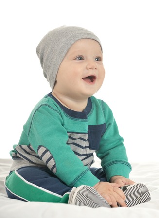 Happy cute baby boy sitting on a white background