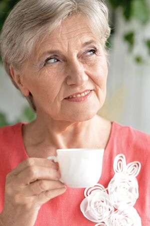 Portrait of senior woman with cup of coffeeの写真素材