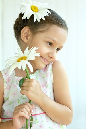 Portrait of  Beautiful little girl with dasies flowersの写真素材
