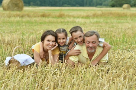 Happy family in wheat field in sunny dayの写真素材