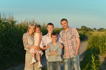 Family having rest in field at sunsetの写真素材