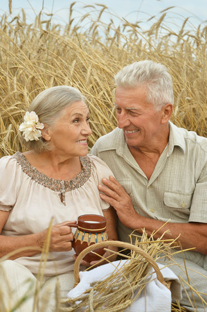 Senior couple resting at summer field  during vacationの写真素材