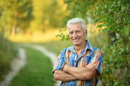 Happy senior man on a walk in the park in summerの写真素材