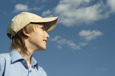 Cute nice boy posing outdoors in summer on sky backgroundの写真素材