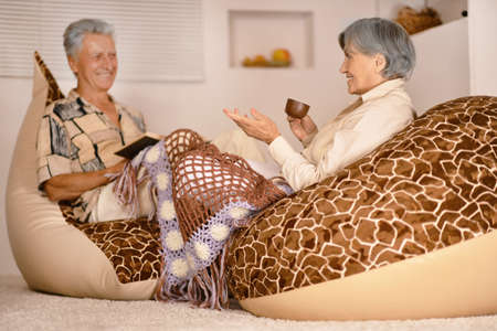 Happy elderly couple resting ,sitting on chairの写真素材