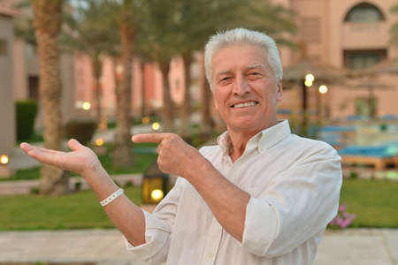 Portrait of an elderly man pointing on tropical resort