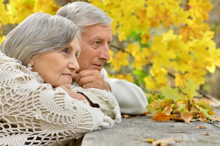 Portrait of a senior couple resting at autumn parkの写真素材