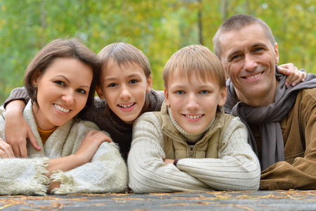 Happy smiling family relaxing in autumn forestの写真素材