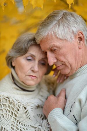 Portrait of a sad senior couple in autumn parkの写真素材