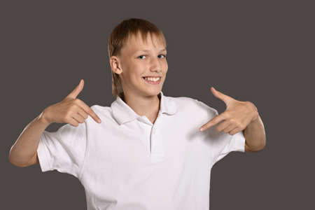 Portrait of a teenage boy pointing  on white backgroundの写真素材