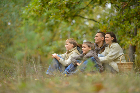 Happy smiling family relaxing in autumn forestの写真素材
