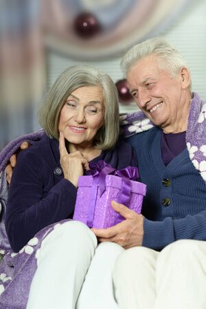 Happy beautiful elderly couple celebrating new year at homeの写真素材