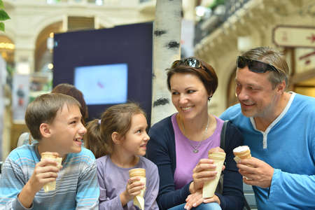 Happy family  walking in city and eating ice-creamsの写真素材