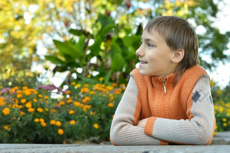 Young boy in park with flowers backgroundの写真素材