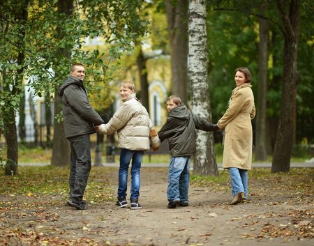 Portrait of happy family relaxing in autumn parkの写真素材