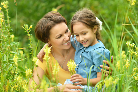 Happy mother and daughter at summer fieldの写真素材