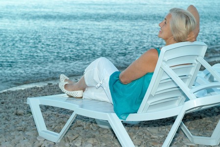 Portrait of a happy elderly woman on beachの写真素材