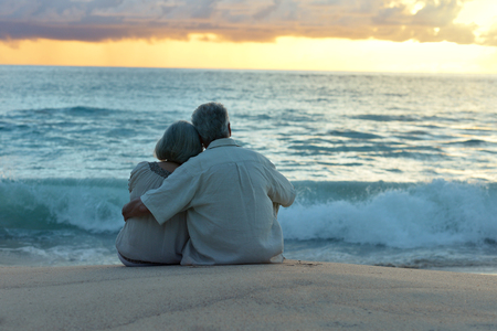 Beautiful happy elderly couple rest at tropical resort,back view