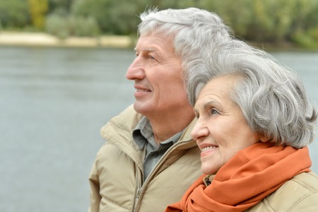 Portrait of beautiful senior couple resting in autumn parkの写真素材