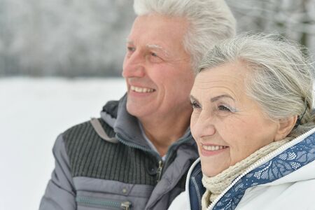 Portrait of elderly couple having fun outdoors in winter forest