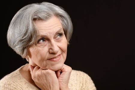 Portrait of a beautiful senior woman on black backgroundの写真素材