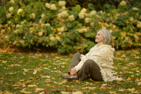 Senior woman in the park in autumnの写真素材