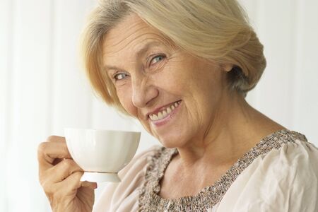 Portrait of senior woman with cup of coffee
