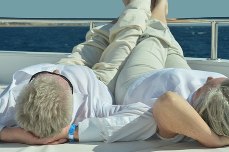 Active smiling senior couple exercising in gymの写真素材