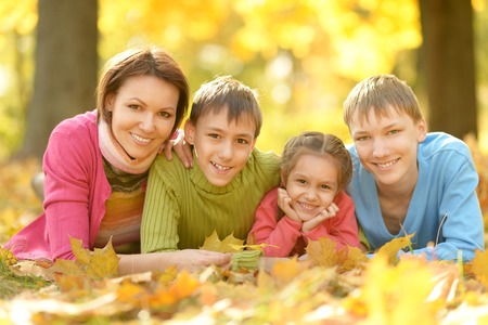 Happy smiling family relaxing in autumn parkの写真素材